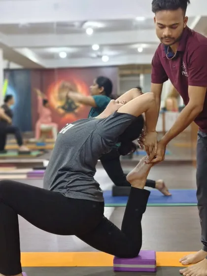 Guiding a student into a deeper expression of Eka Pada Rajakapotasana (One-Legged King Pigeon Pose). My support at her back and foot helps to open the chest and quadriceps safely.