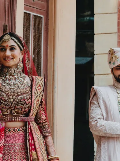 A candid, happy moment between the bride and groom, captured against the beautiful, aged architecture of a traditional setting.