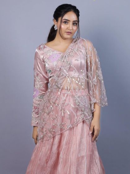 A full view of the baby pink Indo-Western saree from our 'Yuthika' collection. The outfit combines a pleated skirt with a pre-draped, embroidered net pallu for a modern and hassle-free take on the classic saree.