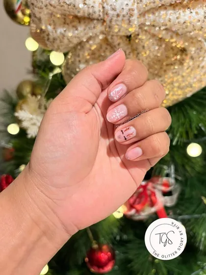 A simple and cute Christmas nail design on natural nails. This look features a hand-painted snowflake and a "ho ho ho" text design.