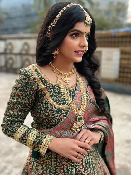 A side profile of the royal bridal look, showcasing the intricate details of the matha patti and the soft, flowing hairstyle.