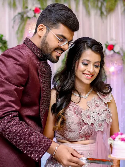 Cutting the cake together is the first sweet task of many. This candid shot captures their teamwork and shared smiles.