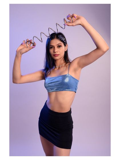 A playful and creative portrait using a metal spring as a prop. The cool lighting and fun pose give this shot a unique and futuristic feel.