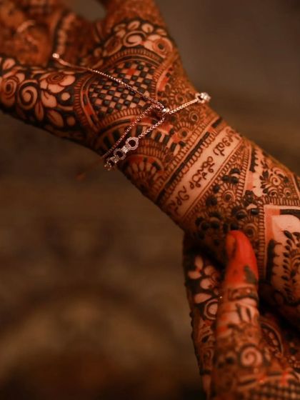 A close-up of the beautiful henna stain, with the couple's names in Kannada clearly visible on the wrist.