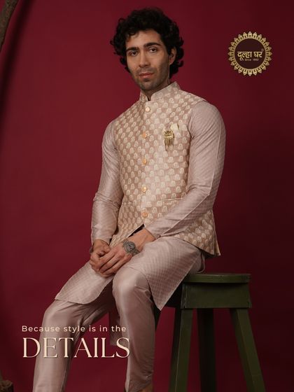 Because style is in the details. A model seated in a beige patterned Nehru jacket and kurta, looking effortlessly elegant.