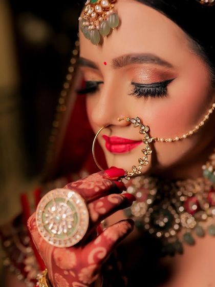 Details matter. This shot highlights the beautiful nath and the perfectly applied lipstick, key elements of a traditional Indian bridal look.