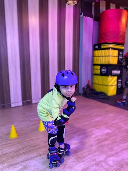 Even our youngest skaters learn with confidence. This little champion is getting comfortable on her quad skates, fully equipped with a helmet and pads because safety is always our first priority.