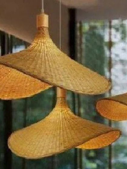 Our iconic umbrella-shaped bamboo pendant lights, shown here in a cluster. The wide, shallow design casts a broad, warm light, making them ideal for illuminating large areas like dining tables or living room seating arrangements.