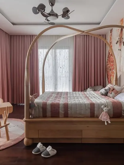 For the daughter's room in the Quintessence project, we created a space that is both whimsical and timeless. The custom-arched four-poster bed serves as a magical centerpiece, complemented by soft pink textiles and a dedicated play table. This design balances a child's playful spirit with sophisticated style that can evolve as she grows.