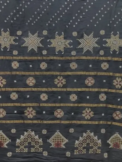 A detail from a Kasuti-embroidered textile, featuring star motifs and temple cart patterns. The beauty of Kasuti lies in its perfect symmetry and the fact that the design is identical on both sides of the fabric.