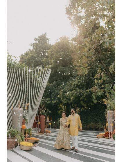 A wide shot of Nikita and Pushkar at their Haldi, showcasing the modern and artistic decor of the event. We capture not just the people, but the beautiful environment they celebrate in.