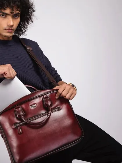 A shot demonstrating the functionality of an Eské Global men's leather laptop bag. The image combines style with practicality, showing the bag in use while maintaining a polished, commercial aesthetic.
