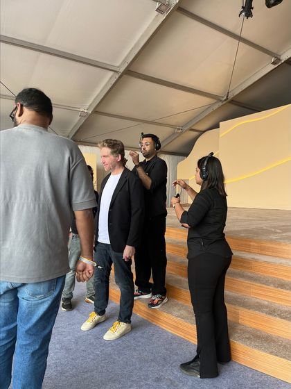 Our team fitting a speaker with a microphone and earpiece backstage at the TATA Sierra event. We ensure all talent is properly equipped before going on stage.