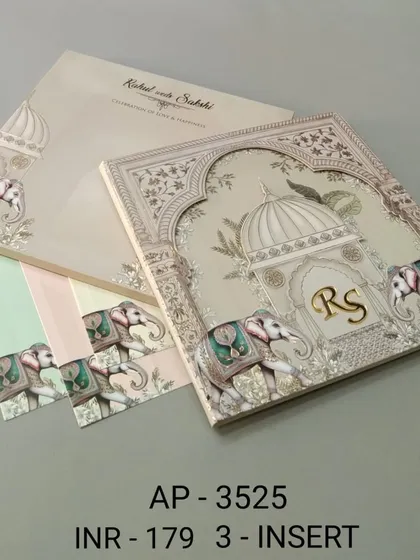 This elegant off-white invitation is adorned with beautifully illustrated elephants and a space for a custom monogram. The set includes three color-coordinated inserts for your various wedding ceremonies.