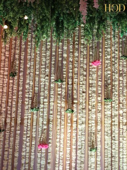 A stunning backdrop made of a dense wall of hanging white flowers, creating a delicate and ethereal texture.