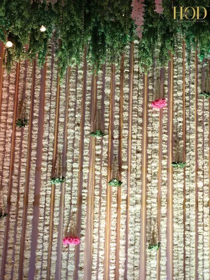 A stunning backdrop made of a dense wall of hanging white flowers, creating a delicate and ethereal texture.