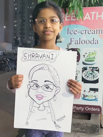 This young guest, Shravani, proudly shows off her finished caricature. I love adding names and small details to make each drawing feel personal.