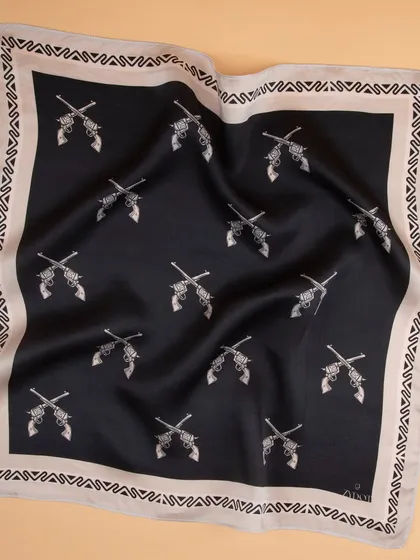 A draped shot of a black pocket square with a repeating crossed-pistols print, showing fabric quality.
