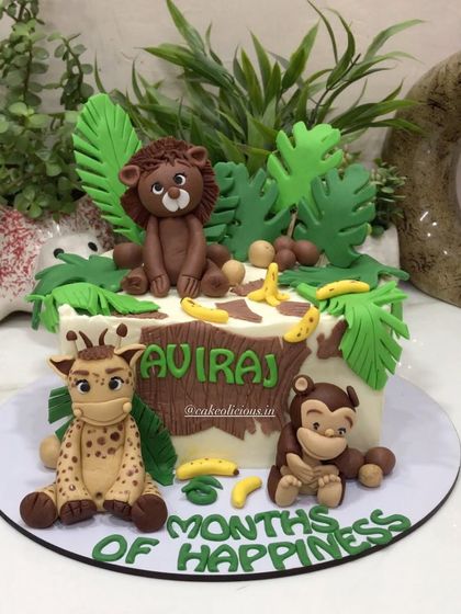 A closer look at the fondant lion and giraffe on the jungle-themed half-birthday cake.