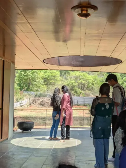 Students gathered on the deck, observing how the circular skylight casts a perfect circle of light on the floor. These are the details that transform a building from a mere structure into a place of poetry and experience.