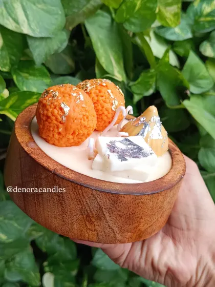 I love bringing a playful touch to tradition with my Indian dessert platter candles. This piece features realistic-looking laddoo, modak, and kaju katli candles, all made from scented soy wax and arranged in a beautiful wooden bowl.