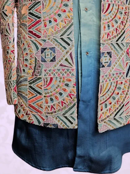 A side view of the geometrically embroidered jacket, highlighting the colorful patterns and the beautiful drape over the ombre kurta.