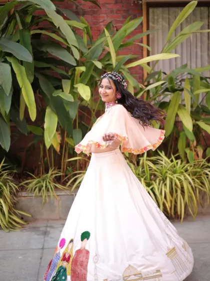 A twirling shot that shows the beautiful movement of her cape and skirt. The floral hair accessories add a bohemian touch to the look.