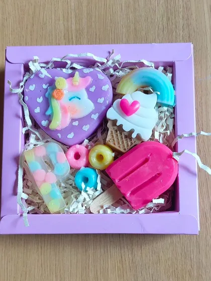 A sweet-themed soap hamper with a unicorn, ice cream, rainbow, and popsicle soap.