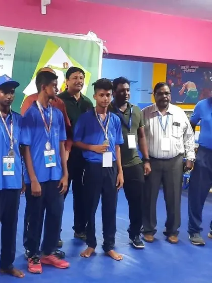 Our young champions standing proudly with their medals alongside the event officials. This photo represents the future of our boxing team.