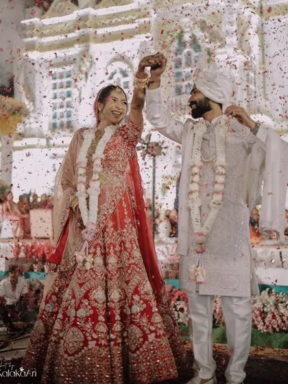 A moment of pure celebration after the varmala exchange, with confetti raining down on the happy couple.