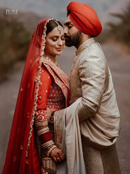 An intimate and romantic portrait of the couple. The groom's gentle kiss on the bride's forehead is a timeless expression of love.