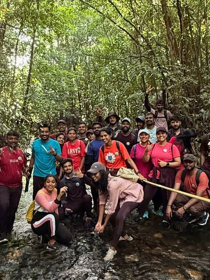 Our trekkers carefully navigating a stream crossing with a rope, showcasing the adventurous spirit of the Kudremukha trek.