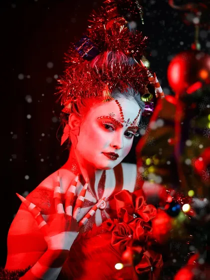 A close-up of the Christmas look, highlighting the glittery red details on the face and the creative use of tinsel in the hair.