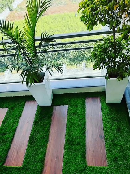 An overhead view of the wooden plank and artificial grass flooring, a practical and beautiful solution for balconies.