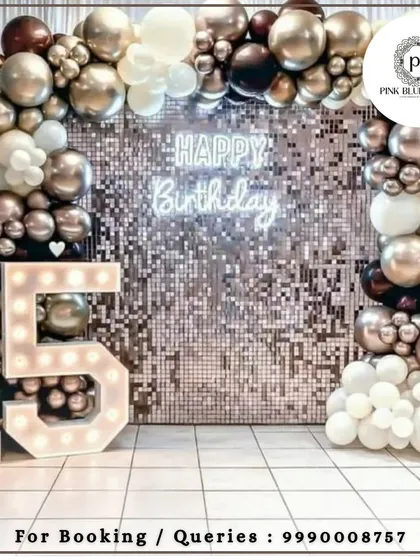 Celebrating a milestone birthday deserves a touch of glamour. This chic setup for a 15th birthday features a sparkling shimmer wall, a custom neon sign, and bold marquee numbers, creating the perfect backdrop for photos and memories.
