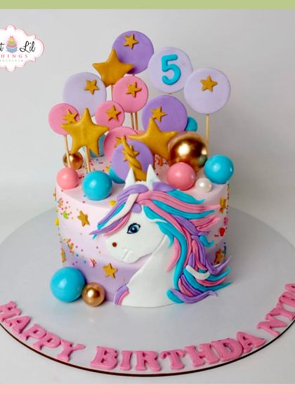 A magical unicorn cake for a 5th birthday. This whimsical creation is adorned with a fondant unicorn, colorful stars, and pastel lollipops for a dreamy celebration.