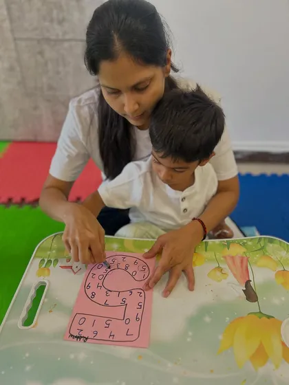 I believe in the power of one-on-one attention. This quiet moment of focused learning shows how we guide each child through Montessori-inspired activities, helping them grasp new concepts like number recognition at their own pace.