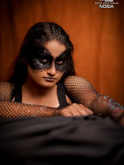 A full-length shot of the black mask fantasy look. The fishnet gloves and dark attire complete this edgy and creative character design.