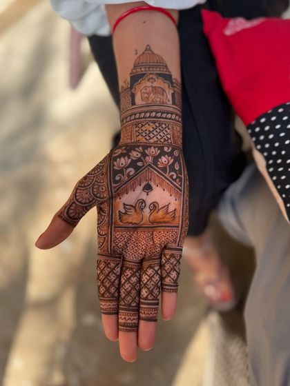 This full hand design combines a portrait of a monument on the wrist with elegant swans on the palm, blending architectural and natural elements.