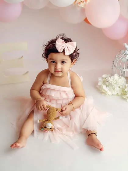 Celebrating 'ONE' in a dreamy setup with pastel balloons and birdcages. This little girl is the star of her own party.