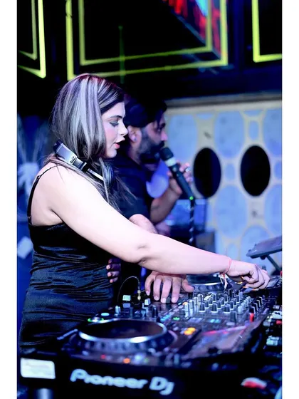 In the zone, mixing tracks at a packed club. This is a close-up of me at the DJ console, focused on blending the perfect beats to keep the party going all night long.