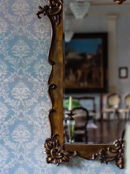 A close-up of an ornate, vintage-style mirror frame, reflecting our ability to work with classic and antique design elements.