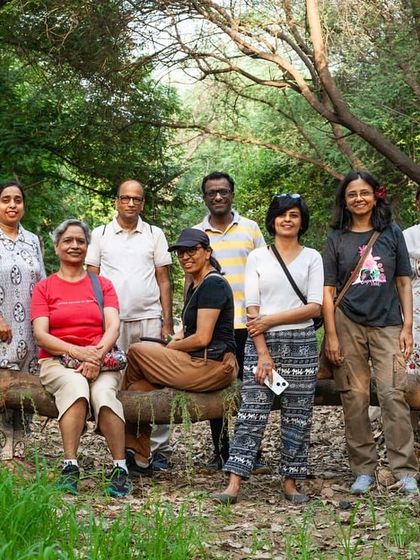 A group of citizens on our "Joy Walk" poses for a photo on a fallen log, feeling connected to nature and each other.