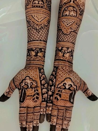 A traditional design featuring swan and peacock motifs, symbolizing love and beauty, set within intricate patterns covering the full arms.