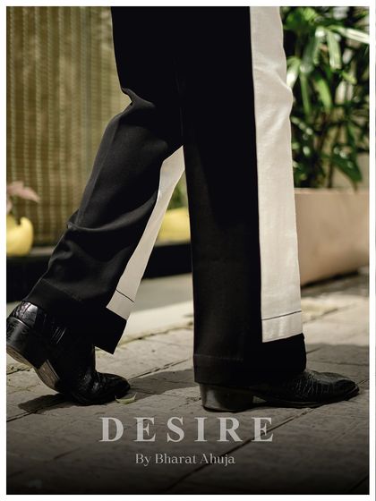 A detail shot of the color-blocked trousers in motion. The sharp contrast of black and white creates a powerful visual with every step.