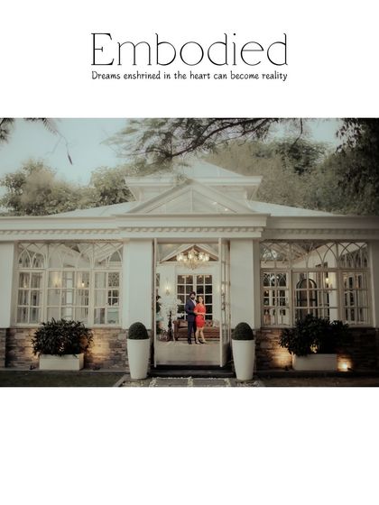 "Embodied." A wide shot of the couple standing in the doorway of a beautiful glasshouse. This image perfectly captures the dreamlike, fairytale quality of the location.