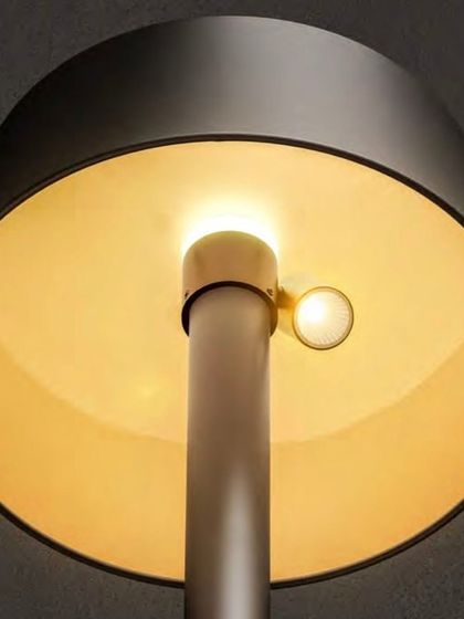 A view from underneath the solar lamp post, showing the warm, downward-cast light source. This design minimizes glare and directs illumination exactly where it's needed on pathways or seating areas.