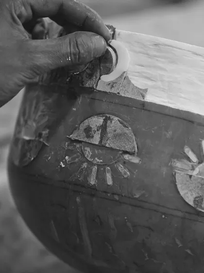 A close-up of the meticulous handcraftsmanship involved in creating the 'Forces of Nature' pillar. This black and white shot highlights the artisan's touch, showing how our conceptual design was brought to life through traditional techniques.
