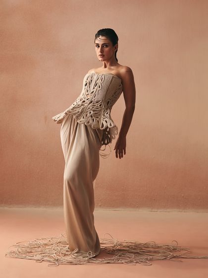 The Karov silhouette, where a strapless, cord-embroidered corset is paired with a fluid satin drape skirt, softening structure with movement.