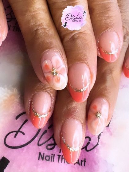 Blossoming in style. This design features pink French tips with a floral twist and a touch of gold glitter for extra sparkle.